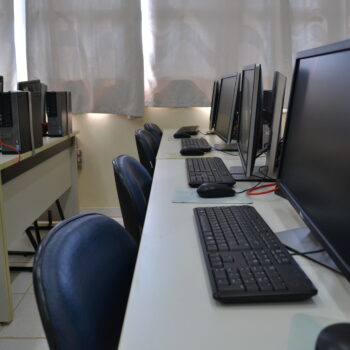 Laboratório de Informática. Fileira de computadores perfilados lado a lado